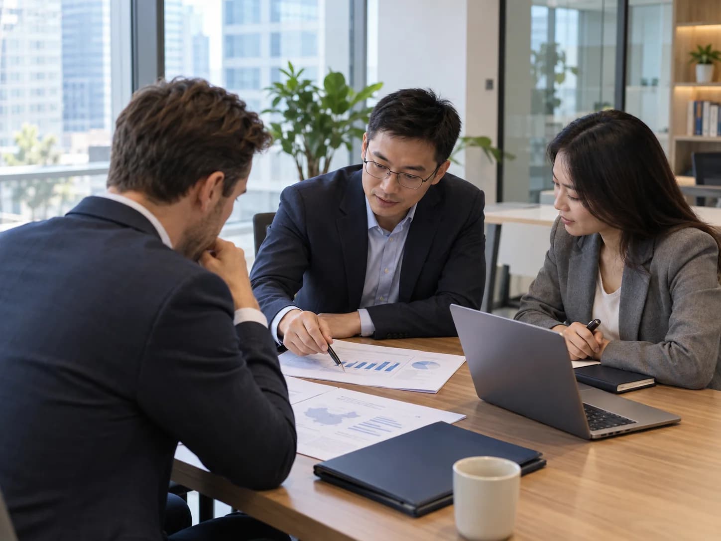 Illustrative scene of advisers and an international client reviewing business documents in an office